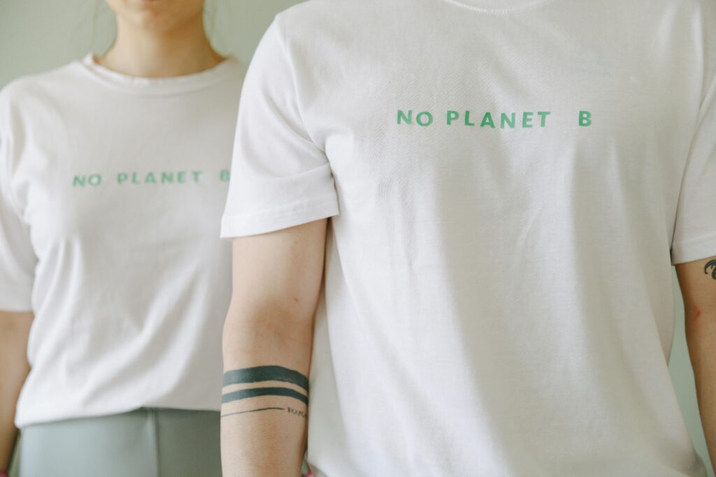 Close-up of two people wearing white 'No Planet B' T-shirts, promoting environmental awareness.